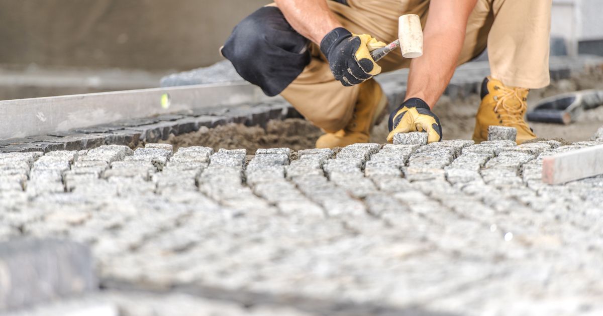 worker paving driveway