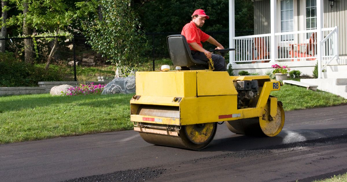 Worker installing asphalt driveway