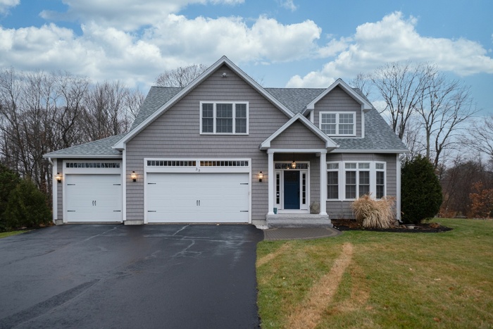 Gray-walled suburban house with asphalt driveway