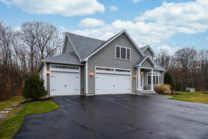 Gray-walled suburban house with asphalt driveway