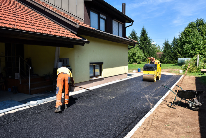 Team of Workers making and constructing asphalt driveway
