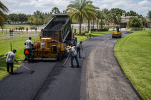 Trinity Asphalt Paving crew applying driveway paving over old asphalt at a horse ranch in Greenacres Florida.